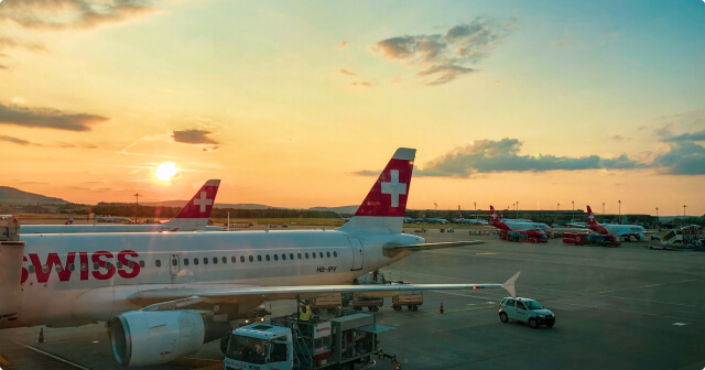 Zwei Flieger der Swiss werden in der Abendsonne aufgetankt.