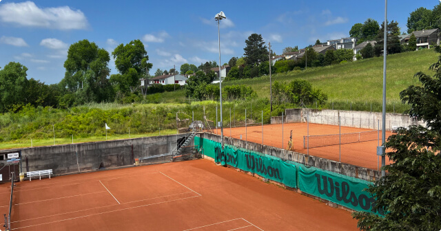 Blaue Tennishardplätze mit überprüfter Flutlichtanlage.